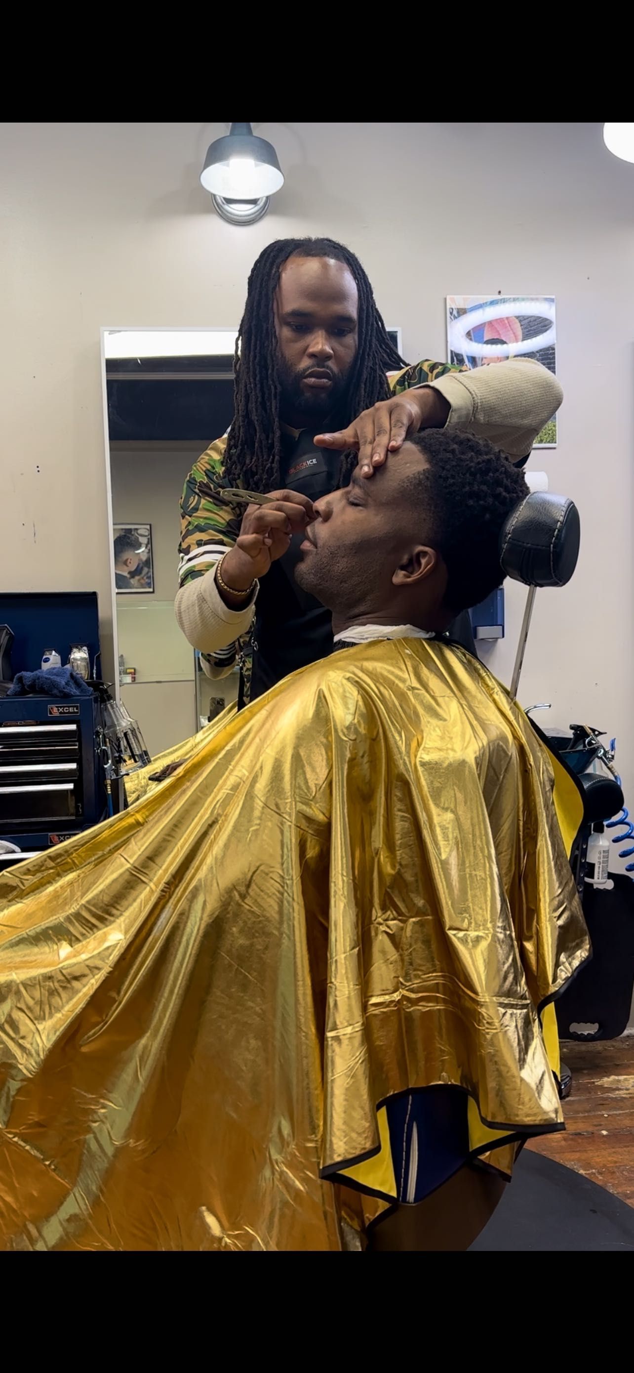 Barber shaping a client’s hairline in the studio